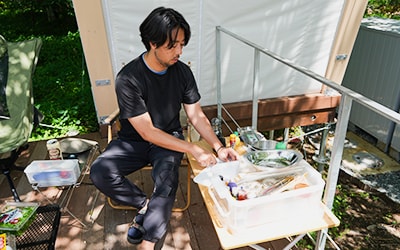 キャンプ用品を並べて準備をしている男性